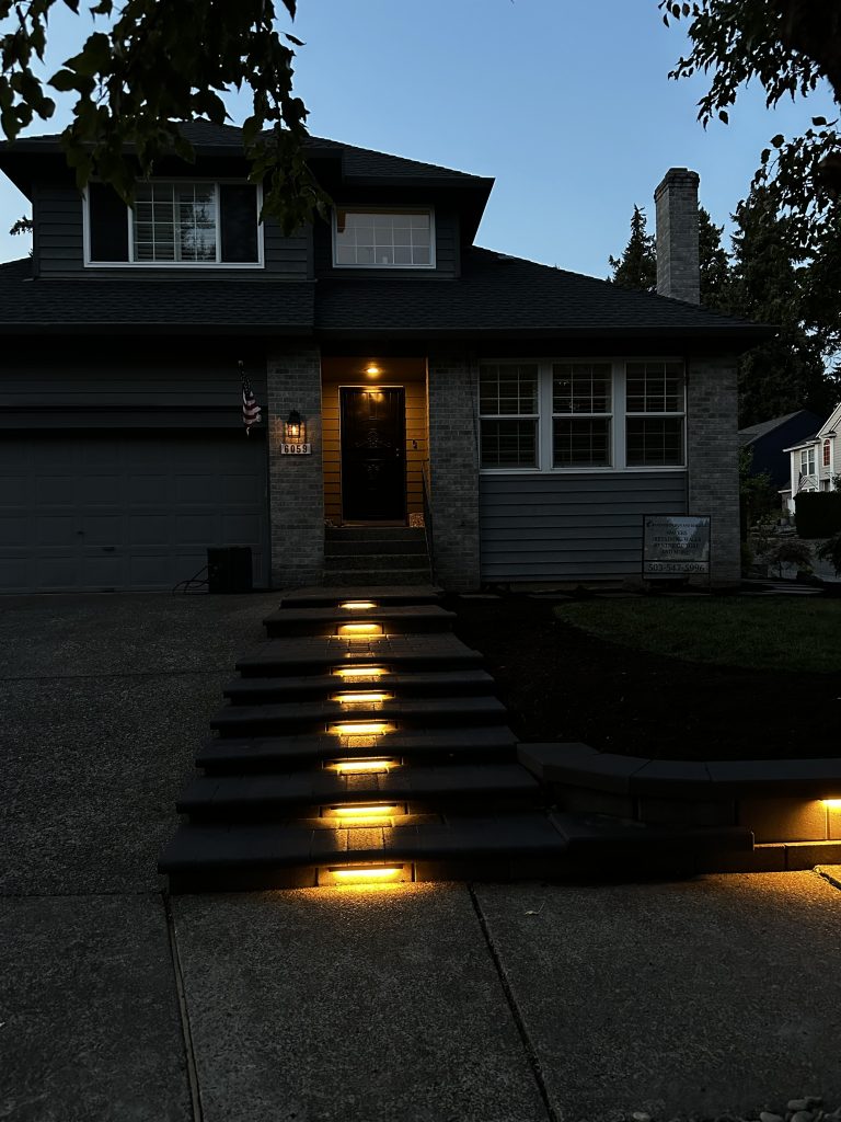Warm lighting along the steps leading to a home.
