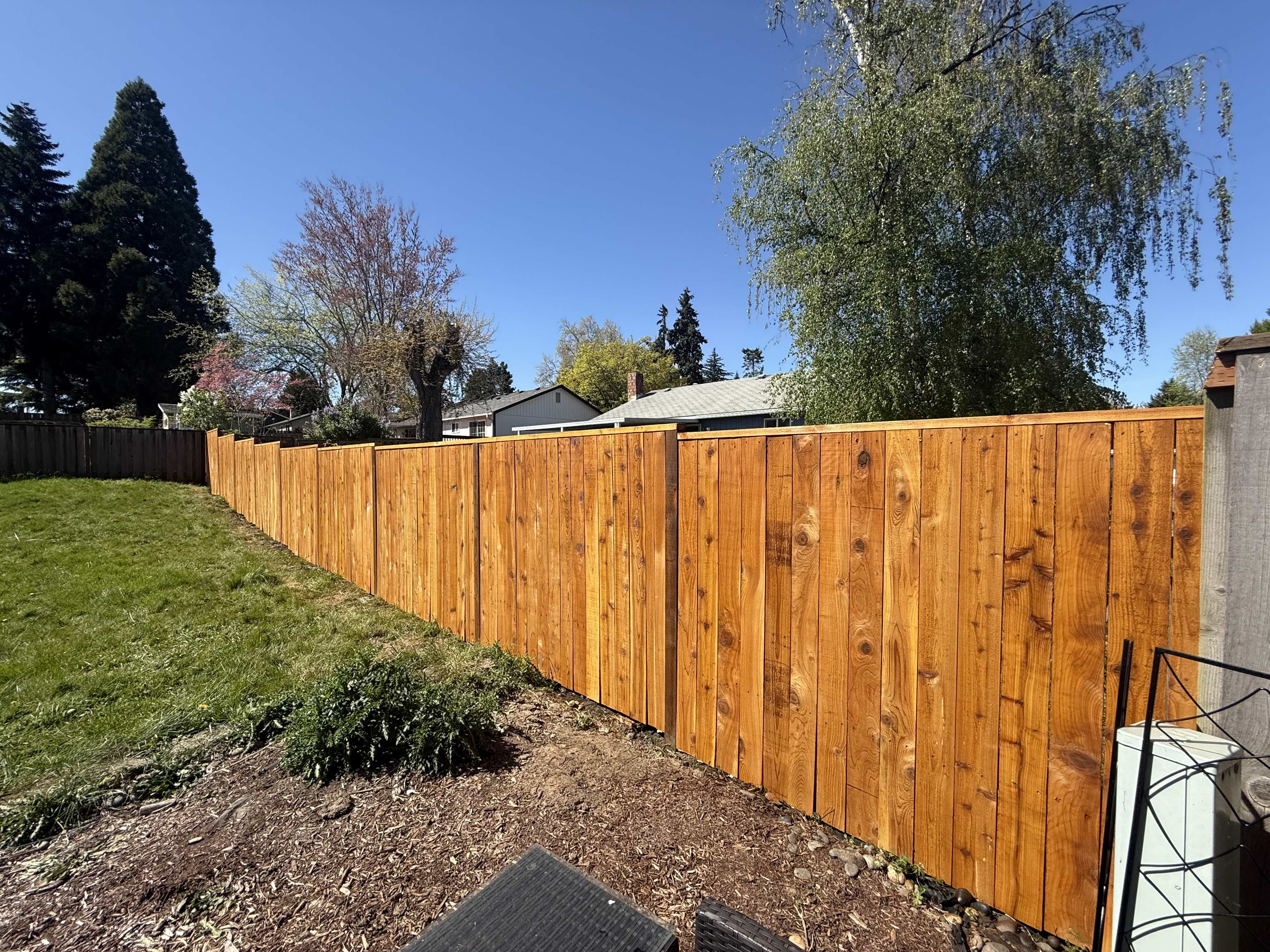 Cedar privacy fence beside a green lawn